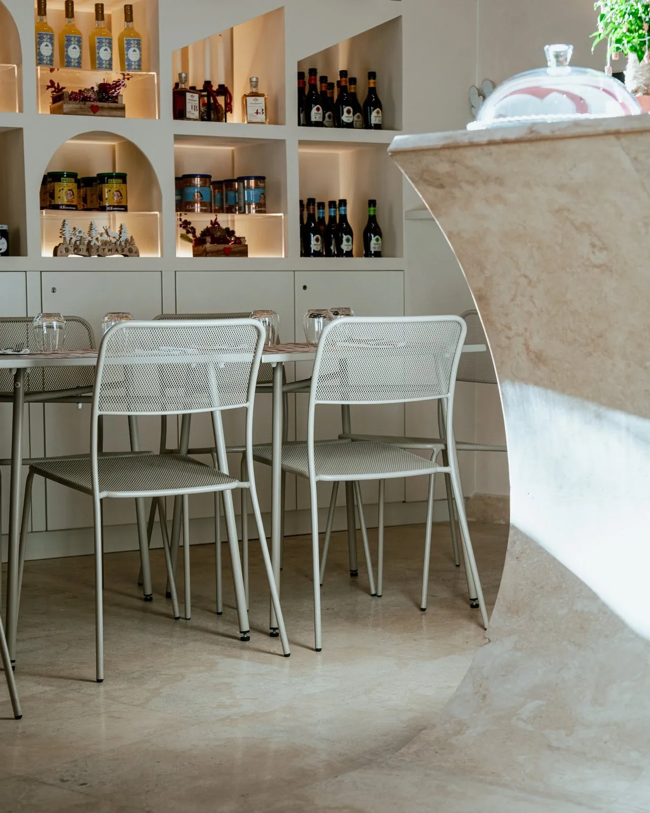 Il bancone in travertino e i tavoli del locale